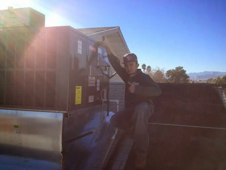 HVAC technician performing AC Tune-Up on a rooftop unit in Hopatcong